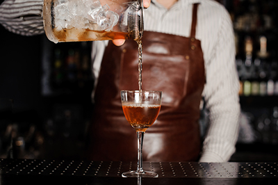 Ein Barkeeper bereitet einen Cocktail zu