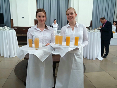 Zwei Servicekräfte beim Servieren von Getränken