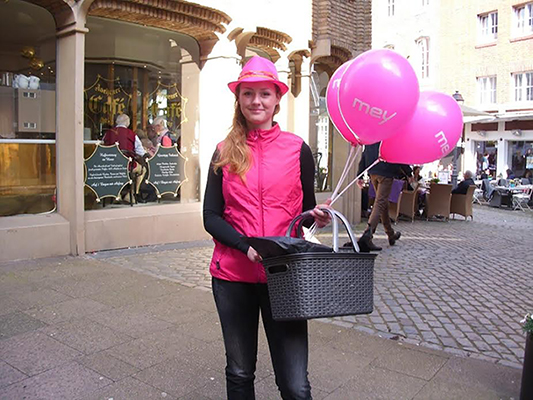 Promoterin beim Verteilen von Flyern und Luftballons